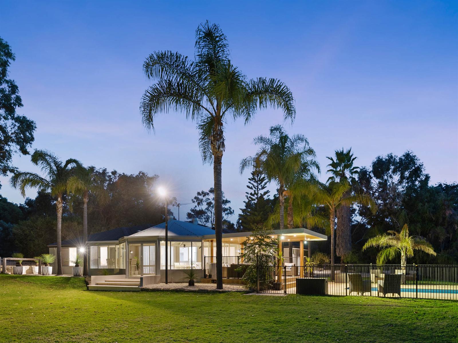 The rear of the home and pool at dusk